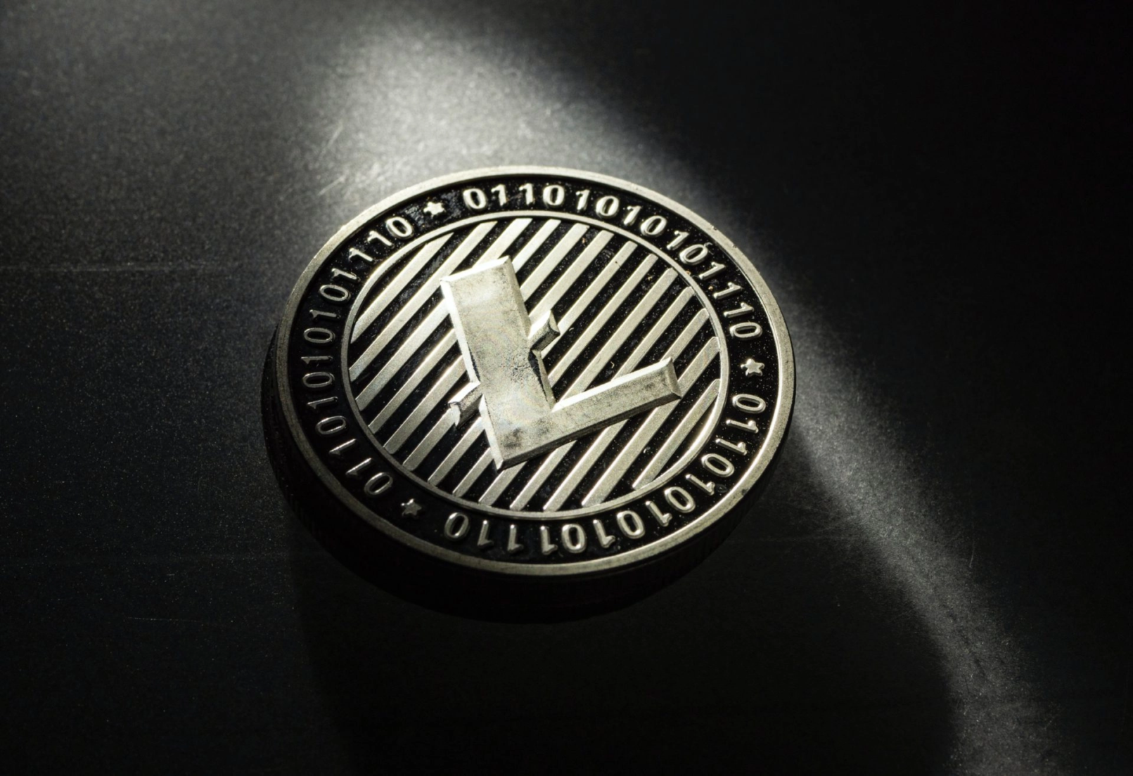 Zilverkleurige Litecoin munt met binair patroon op donkere achtergrond