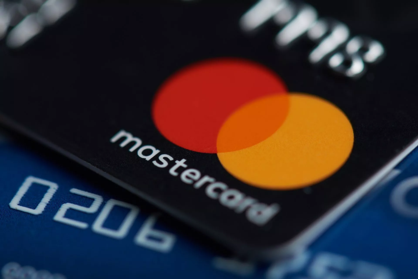 Close-up van Mastercard creditcard met duidelijk zichtbaar logo op zwarte achtergrond