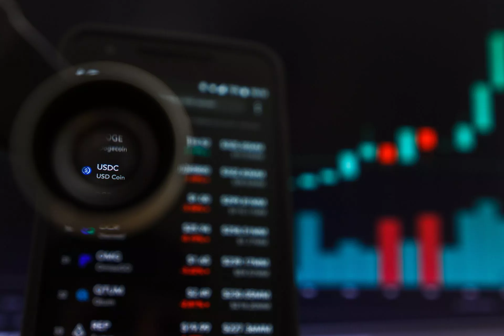 USDC stablecoin weergegeven op smartphone met koersgrafiek op achtergrond