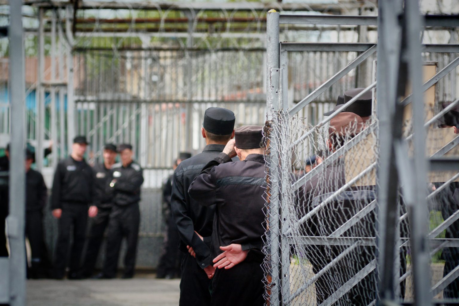 Russische gevangenen in uniform binnen hekwerk van strafkolonie
