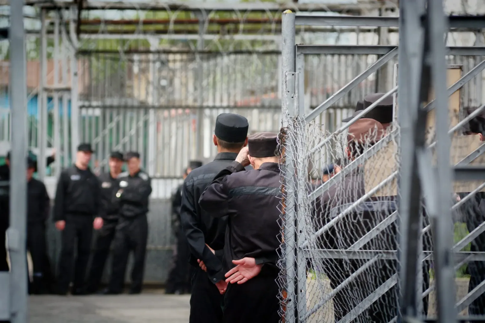 Russische gevangenen in uniform binnen hekwerk van strafkolonie