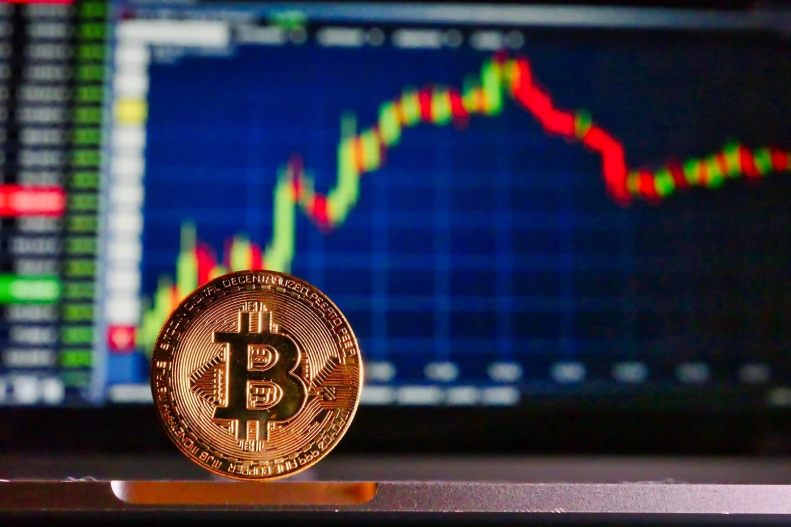 Pièce physique de Bitcoin avec graphique des cours en arrière-plan