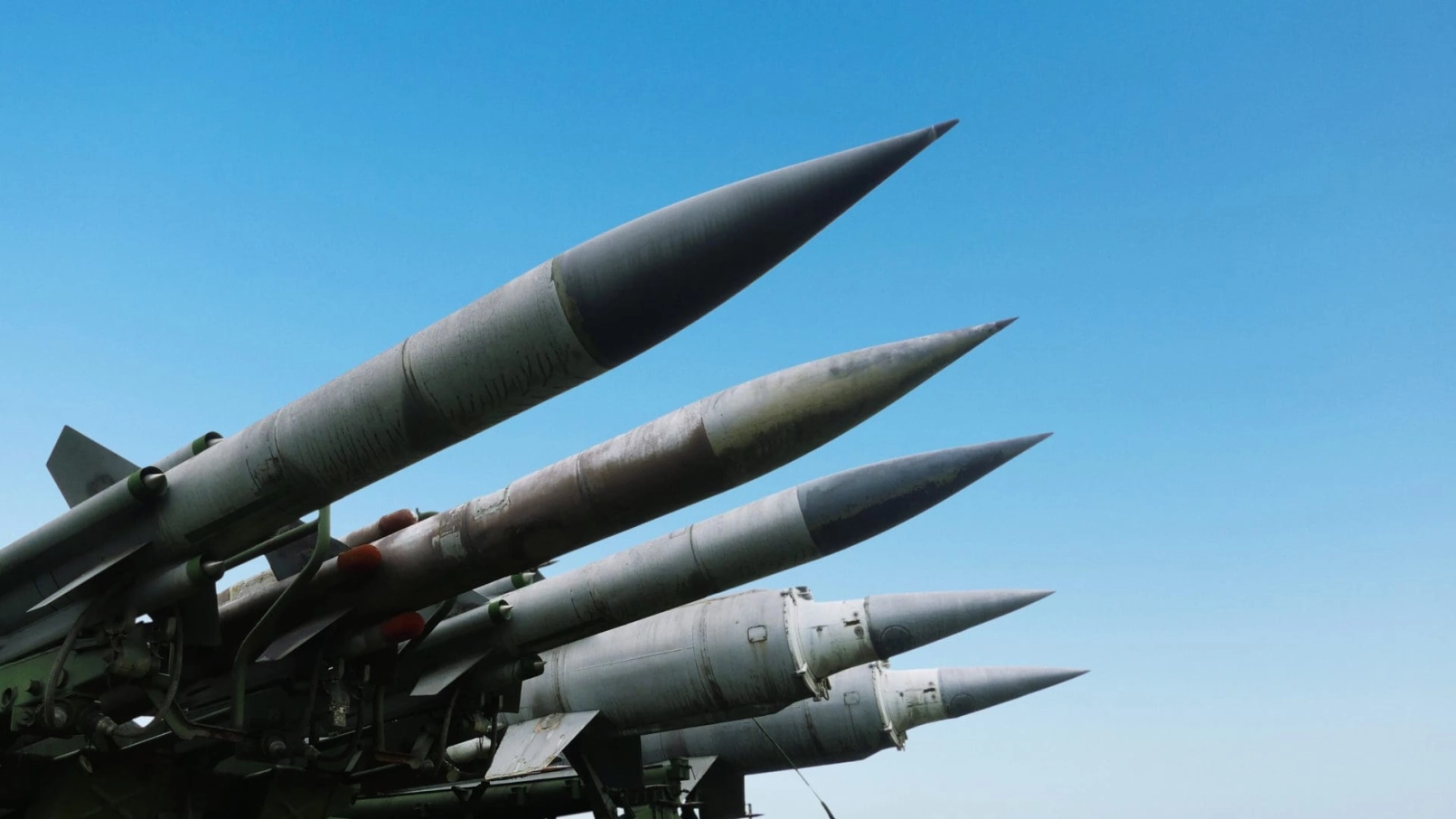 Quatre missiles militaires pointés vers le ciel sur fond de ciel bleu dégagé